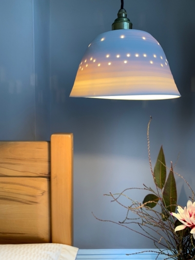 This pretty porcelain pendant lamp by ceramicist Jacqui Roche creates a lovely luminous bedside ambience.
